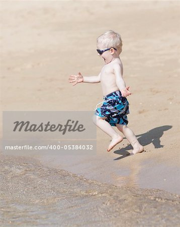 adorable little boy running at the beach