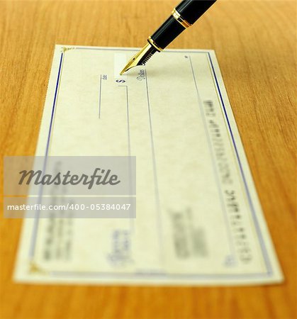 business transaction using a check, shallow focus on the pen tip