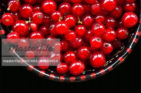 Bowl of red currant isolated in black.