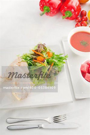 tuna fish and cheese sandwich with fresh mixed salad ,watermelon and gazpacho soup on side,with fresh vegetables on background ,