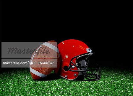 American football and helmet on field