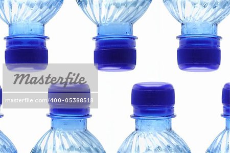 Elevated view of rows of mineral bottles on white