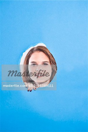 Young Woman Looking Through Hole