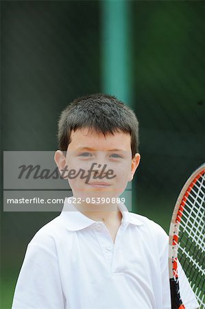Portrait de jeune garçon tenant une raquette de Tennis