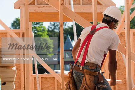 Carpenter carrying a wooden rafter