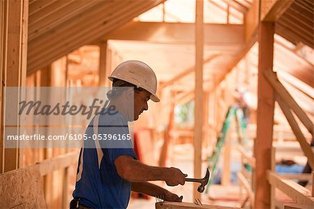 Clous de charpentier hispanique martelage à bord dans une maison en construction