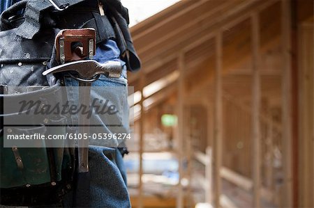 Hammer in the tool belt of a Hispanic carpenter