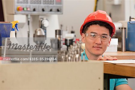 Engineering student studying in a machine lab