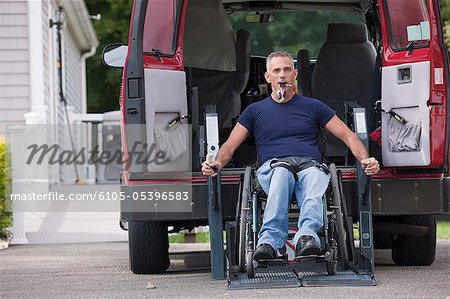 Homme avec la moelle épinière dans un fauteuil roulant dans sa fourgonnette accessible