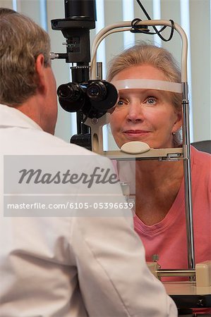 Ophthalmologist examining a woman's eyes with a slit lamp