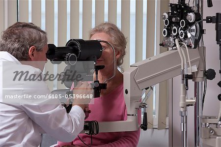 Ophthalmologist examining a woman's eyes with a keratometer