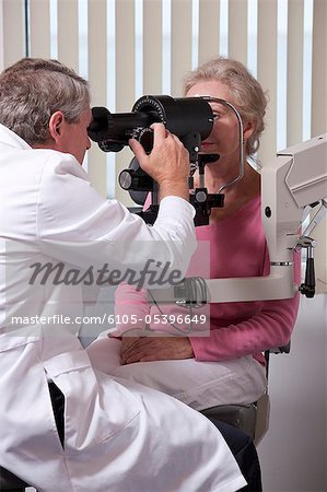 Augenarzt untersucht die Augen einer Frau mit einem Ophthalmometer