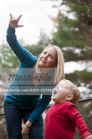 Woman signing the word 'Airplane' in American Sign Language while communicating with her son