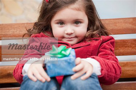 Portrait d'une jeune fille tenant un cadeau de Noël