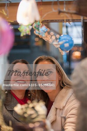 Woman looking at Christmas decorations at a store with her daughter