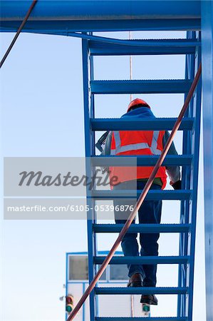 L'ingénieur sur l'escalier supérieur d'installations industrielles