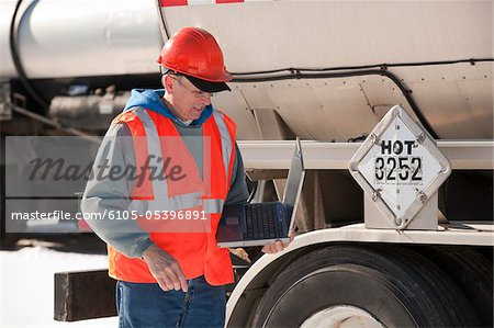 Ingénieur de consignation des données sur un ordinateur portable à des camions citernes