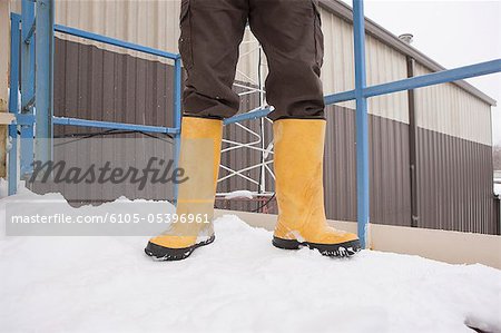 Industrial engineer standing in snow at garage site