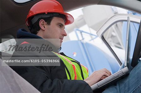Ingénieur à l'aide d'un ordinateur portable dans le camion au lieu de ravitaillement