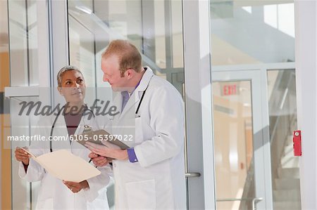 Two doctors discussing a medical report in hospital