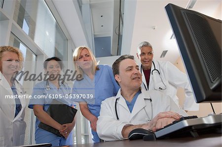 Doctors and nurses consulting on a computer in hospital