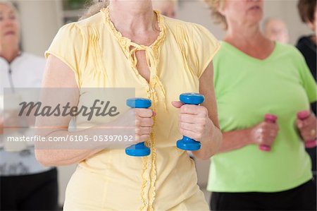 Seniors exercising with dumbbells in a health club