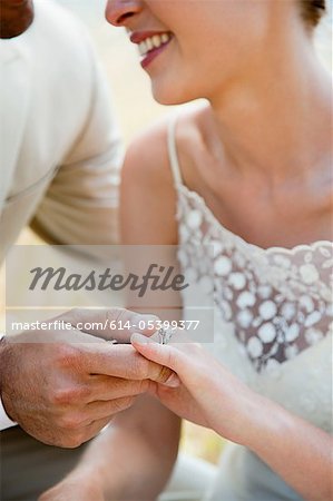 Newlyweds looking at wedding ring, close up