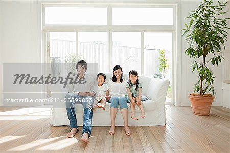 Familie mit zwei Kindern auf dem Sofa, Porträt