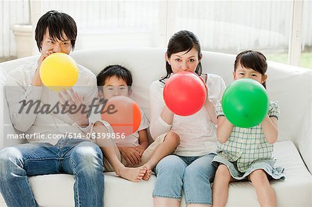 Familie mit zwei Kindern Luftballons Sprengung