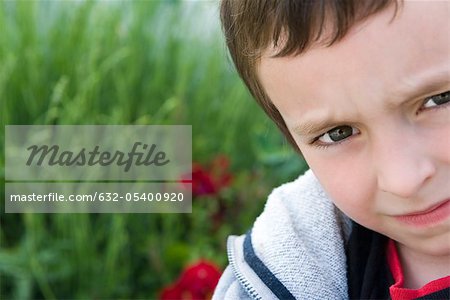 Boy looking at camera with furrowed brow, portrait