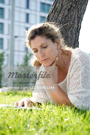 Frau liegend auf Gras Buch zu lesen
