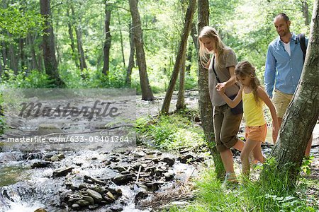 Famille de randonnée le long des cours d'eau en bois