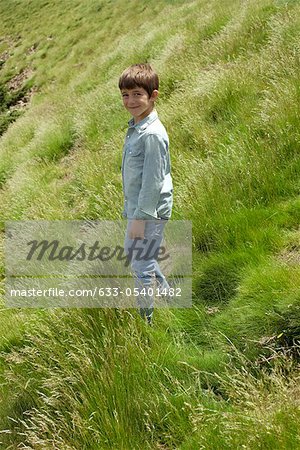 Boy walking on hillside, portrait