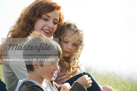 Mother and two children relaxing together outdoors