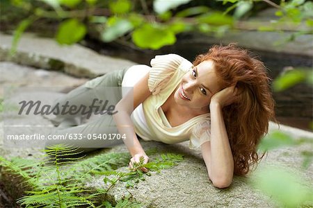 Jeune femme reposante sur la roche
