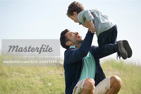 Fils de père et de jeunes jouent dehors