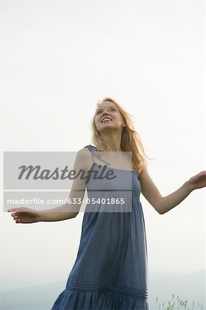 Young woman outdoors, looking up