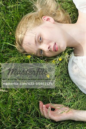 Jeune femme couchée sur l'herbe