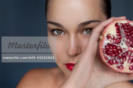 Woman holding halved pomegranate Woman holding halved pomegranate