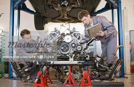 Mechanics working on car engine