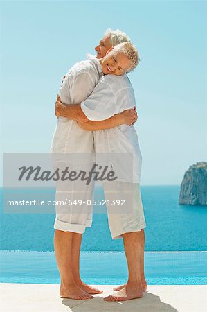 Couple hugging and overlooking sea
