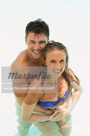 Couple s'enlaçant en piscine