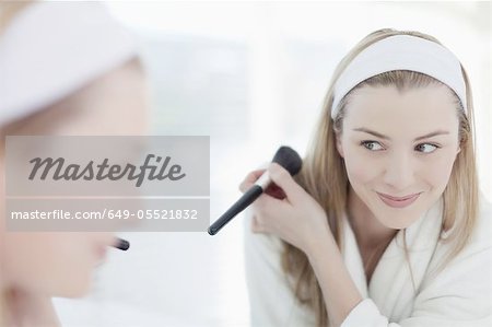 Smiling woman applying makeup