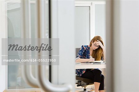 Young female fashion designer working at desk