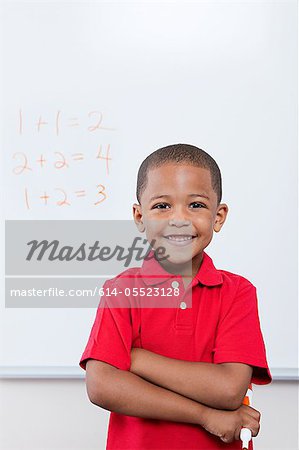 Happy schoolboy in front of mathematics on whiteboard