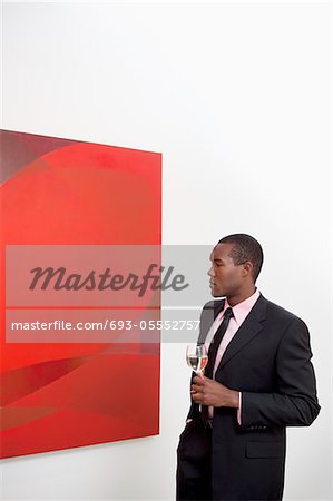 Young man looking at wall painting in art gallery