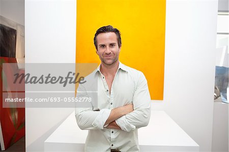Half-length portrait of smiling young man in front of yellow painting