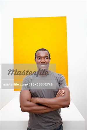 Half-length portrait of smiling young man in front of painting