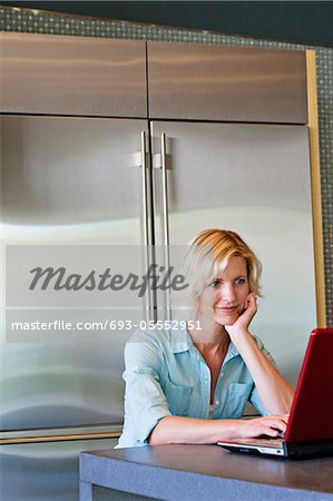 Senior woman with hand on chin using laptop