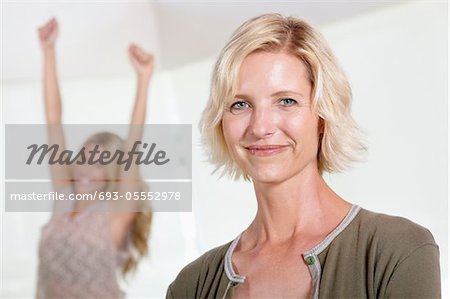 Close up of mother with excited daughter raising hands